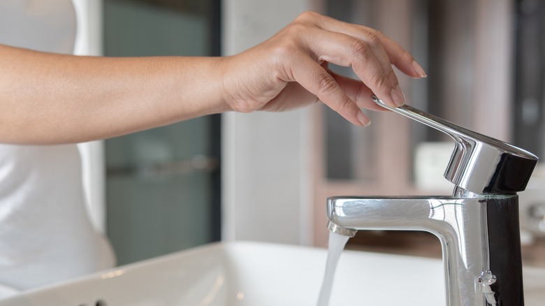 Person turning on a faucet