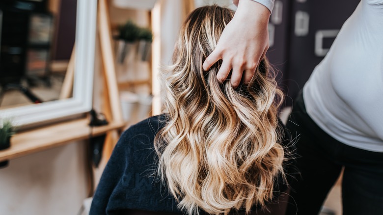 Woman with blonde balayage in salon chair