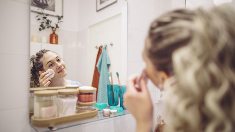 Woman applying skincare to face