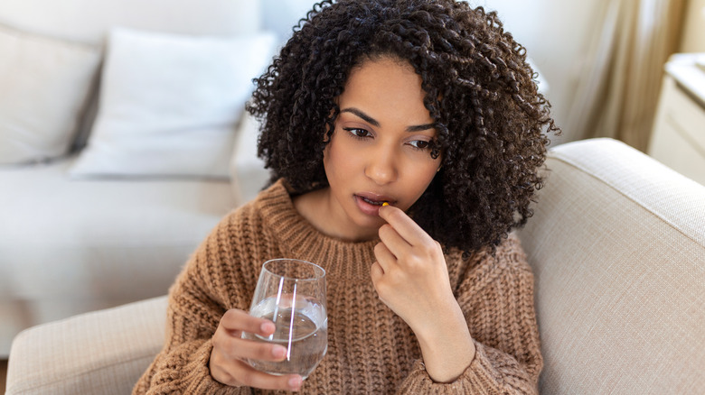 Woman taking a pill with water