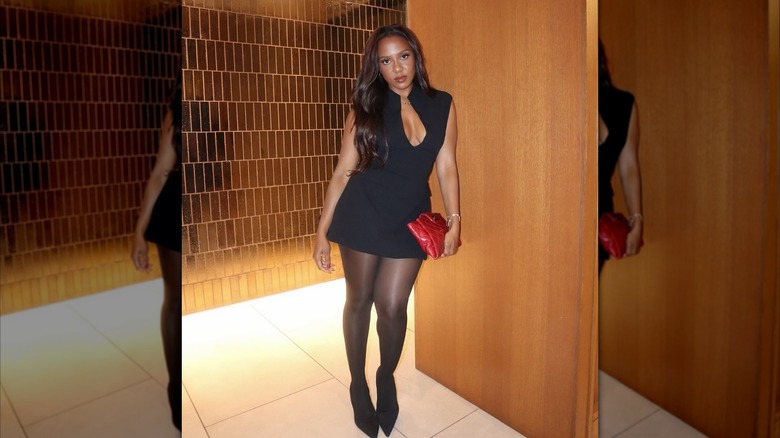 A woman in a black dress with black tights