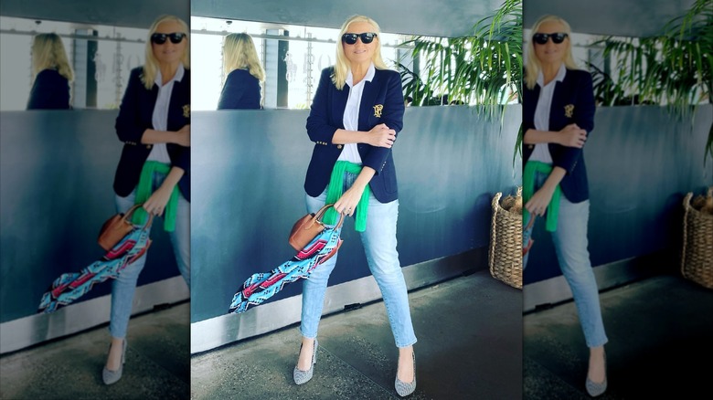 A woman posing with a scarf on her bag