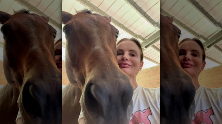Gabrielle Anwar smiling next to her horse
