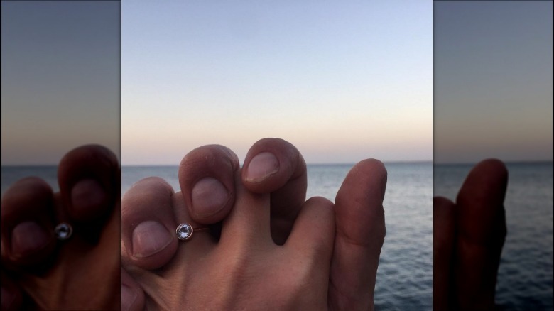 Julia Stiles hand wearing engagement ring