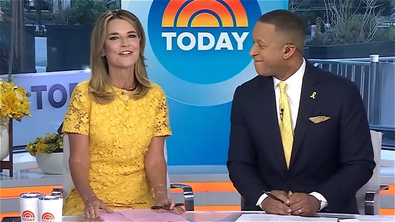 Savannah Guthrie in a yellow dress sitting alongside Craig Melvin in a suit with a yellow tie