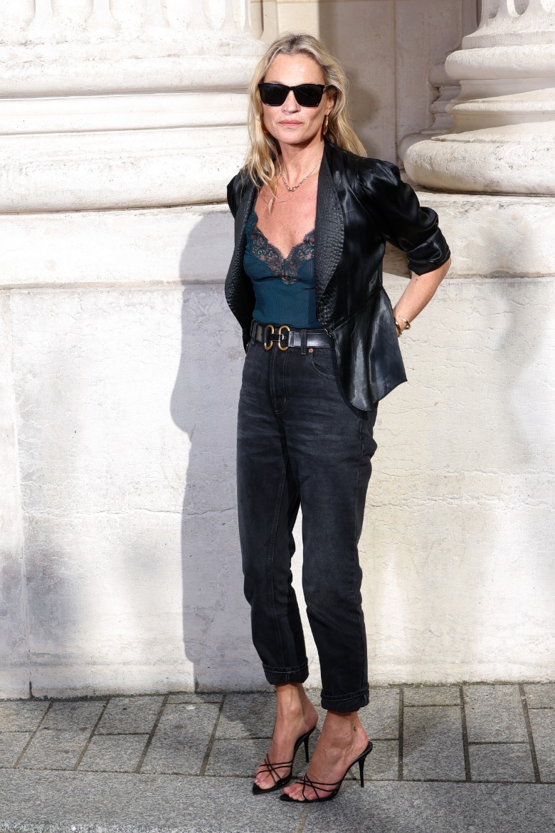 Kate Moss standing in front of a building while wearing high-waisted