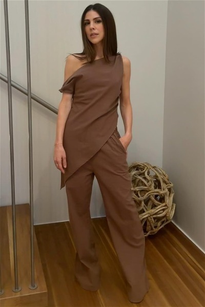 Kate Mansi posing by a staircase in a brown co-ord