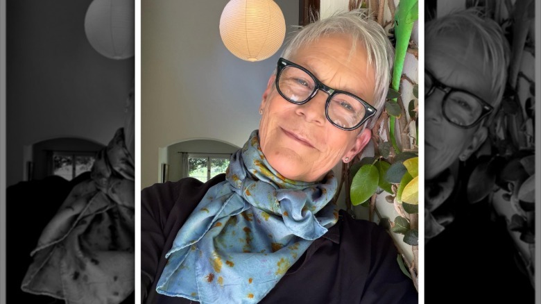 Jamie Lee Curtis smiles as she leans against the wall