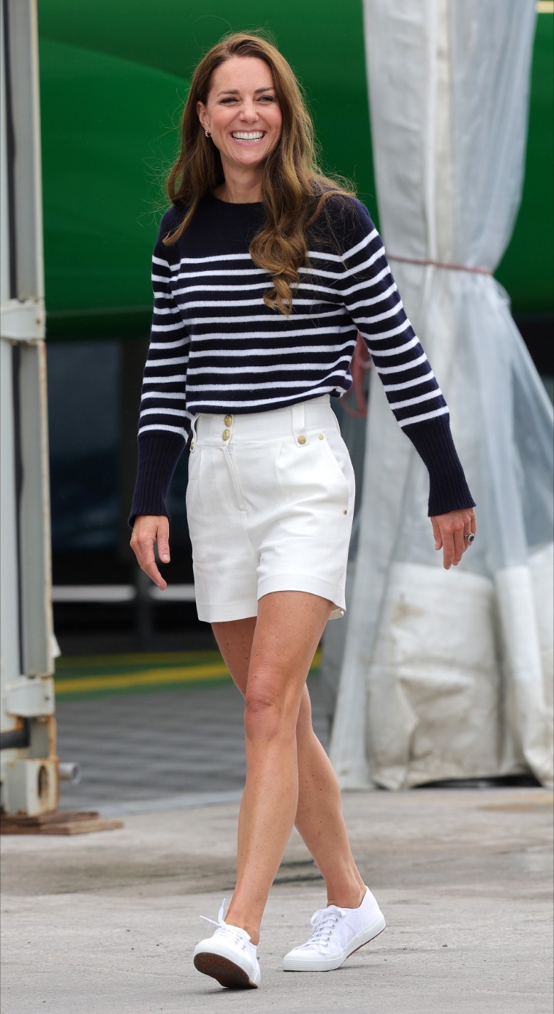Kate Middling pictured smiling and walking while wearing white shorts and a blue-and-white sweater