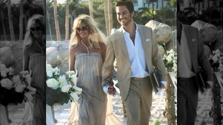 Goldie Hawn and Oliver Hudson holding hands and smiling