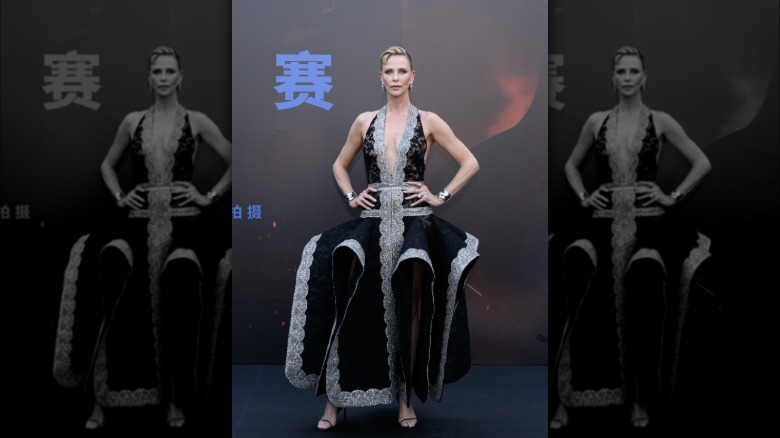 Charlize Theron posing on a red carpet in 2026