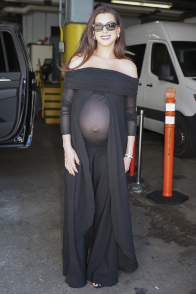 Anne Hathaway smiling in a black sheer top